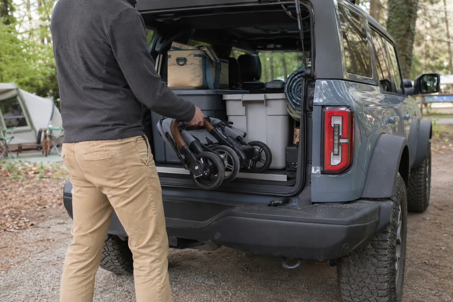 Which Ford Bronco Is the Biggest? 2026 Size Comparison Camping gear and a folded stroller being loaded into a four-door Ford Bronco